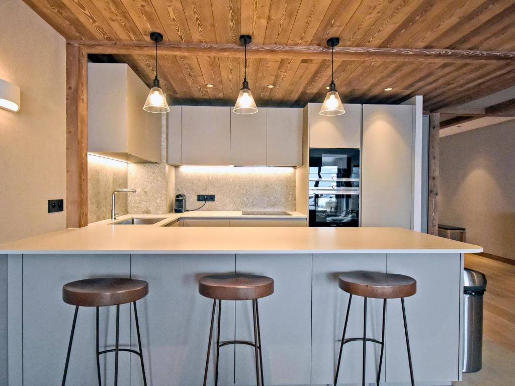 kuchnia z blatem z stołkami wokół niego w obiekcie Appartement de standing, 3 chambres, terrasse, conciergerie, centre Méribel - FR-1-613-45 w mieście Les Allues