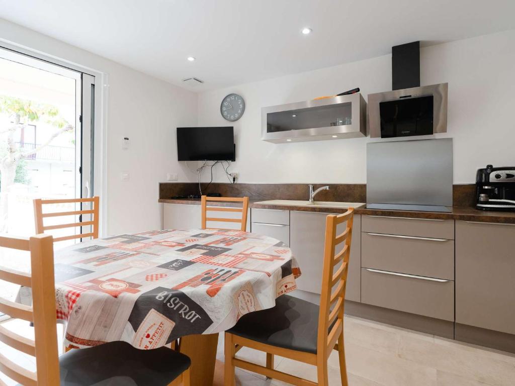 une cuisine avec une table et des chaises et une cuisine avec un comptoir dans l'établissement Appartement T3 climatisé, rénové avec goût, à 150m de la plage, avec terrasse et équipements complets - FR-1-409-204, à Fleury