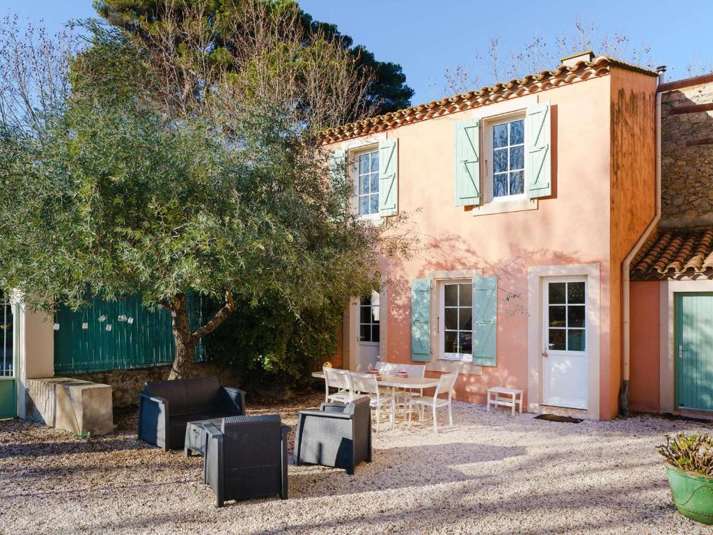 une maison avec une table et des chaises devant dans l'établissement Maisonnette de charme au cœur d'un domaine viticole, près de la plage - Narbonne-Plage - FR-1-409-178, à Narbonne