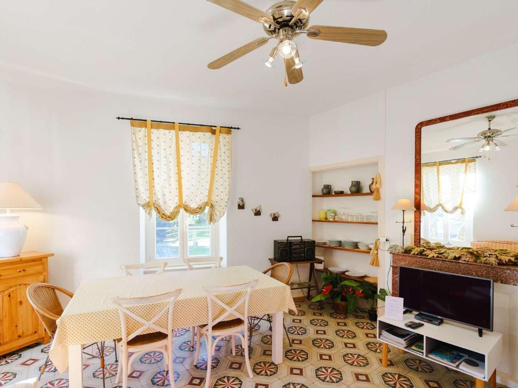 d'une salle à manger avec une table et un ventilateur de plafond. dans l'établissement Appartement Spacieux dans Domaine Viticole à 2 km de Narbonne-Plage, 3 Chambres, Accès WiFi Inclus - FR-1-409-180, à Narbonne