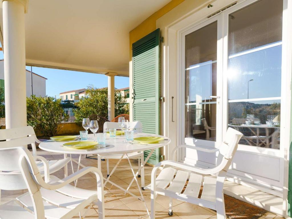 comedor blanco con mesa y sillas en el balcón en Appartement Narbonne-Narbonne Plage-Narbonne Plage, 3 pièces, 4 personnes - FR-1-409-181, en Narbona