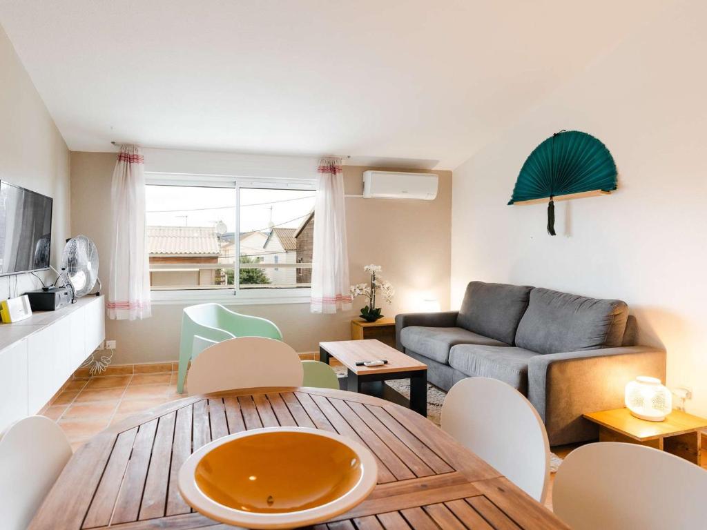 un salon avec une table et un canapé dans l'établissement T2 Mezzanine climatisé pour 5 pers, plage des Chalets, parking, mer à Gruissan - FR-1-409-186, à Gruissan