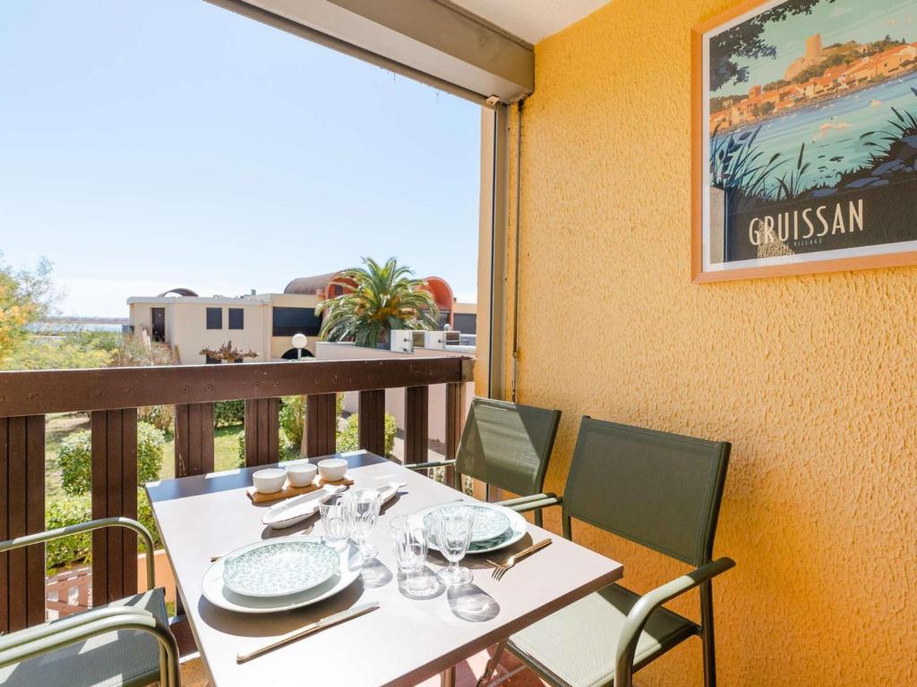 une table et des chaises sur un balcon avec vue sur l'océan dans l'établissement T2 climatisé près plage, parking, cuisine tout équipée, balcon - Gruissan - FR-1-409-227, à Gruissan