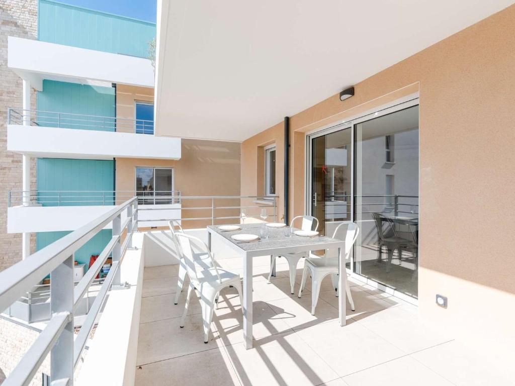 une salle à manger avec une table et des chaises sur un balcon dans l'établissement T3 climatisé, proche plage, neuf, WIFI inclus, parking privé - FR-1-409-230, à Narbonne