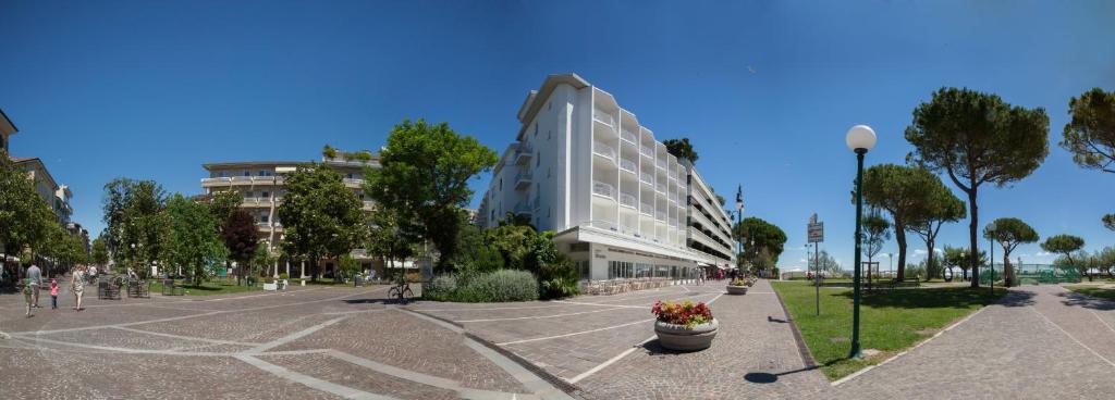 a building with a lot of flowers in a parking lot at Albergo alla Spiaggia in Grado