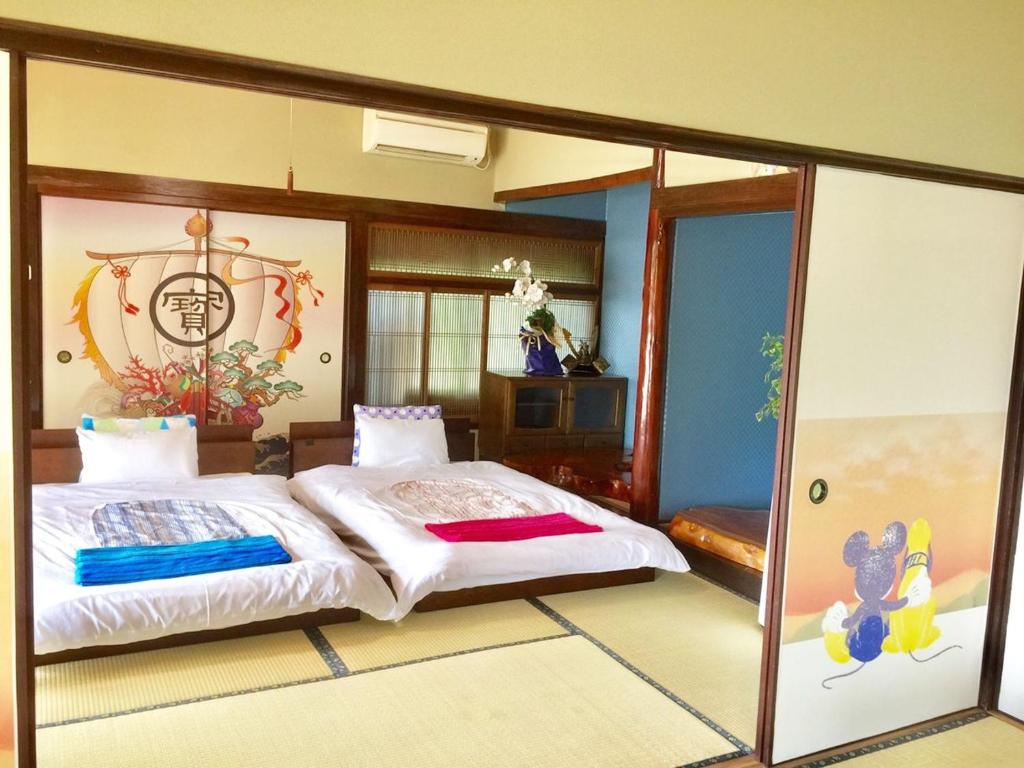 a bedroom with a large bed and a glass wall at 天ゆふ(Ten Yufu) in Yufuin