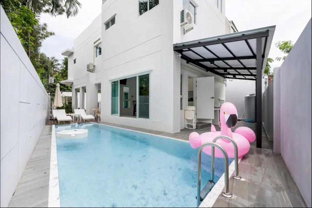 uma casa com uma piscina com um elefante cor-de-rosa sentado ao lado em golf pool villa close patong and phuket town em Kathu