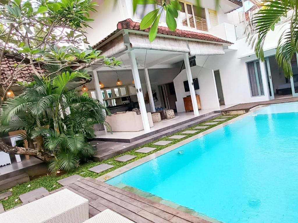 a villa with a swimming pool in front of a house at Villa Oceana I - 3BR private villa with pool in Legian