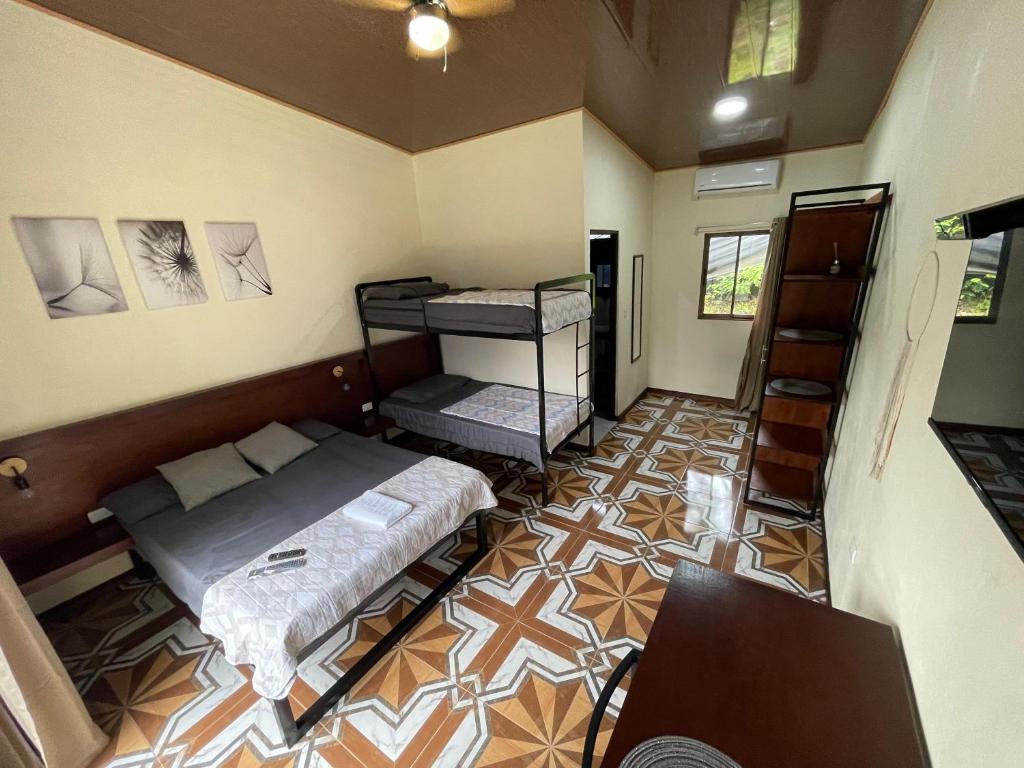 a room with two beds and a desk in it at POSADA MIRADIA in Matapalo