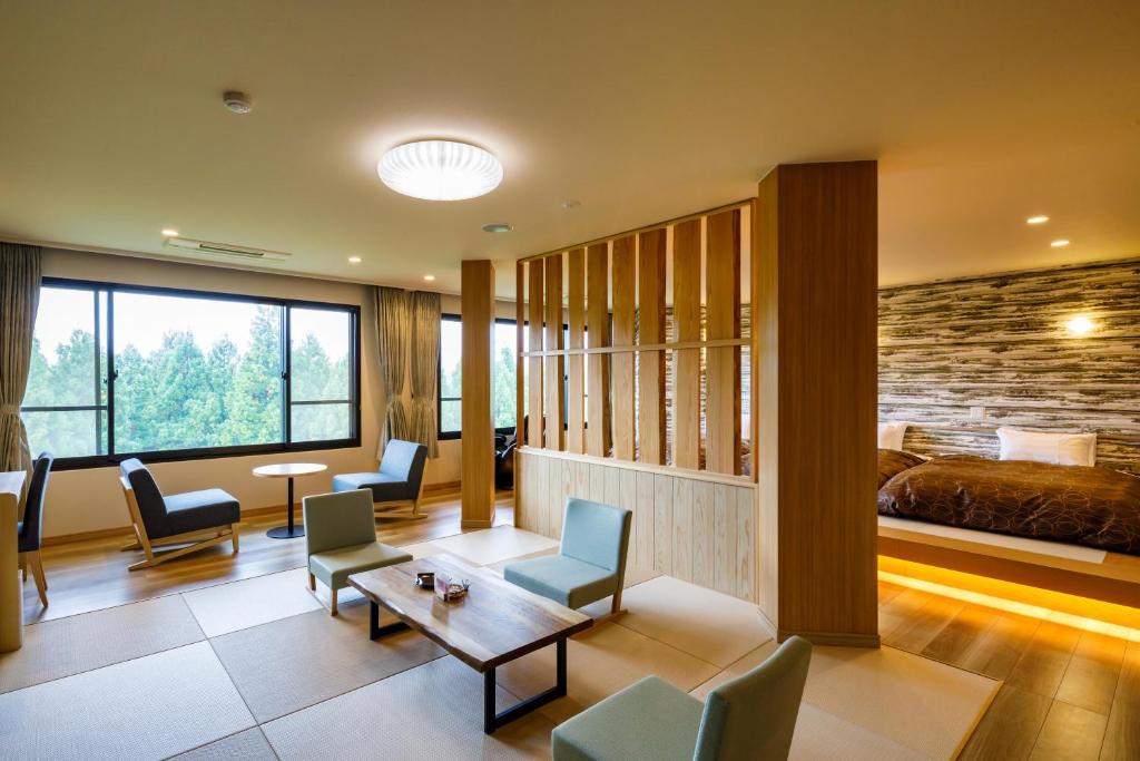 a hotel room with a bed and a table and chairs at 田沢湖水沢温泉郷セルリアンリゾートAoni in Senboku