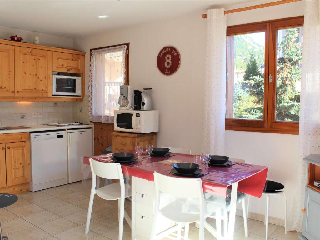 une cuisine avec une table avec des chaises et un micro-ondes dans l'établissement Appartement cosy 3 pièces, 4 couchages, proche des pistes et commerces à Vars Les Claux - FR-1-330B-212, à Vars