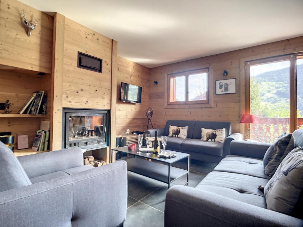 a living room with two couches and a fireplace at Chalet Méribel, 5 pièces, 8 personnes - FR-1-688-64 in Méribel