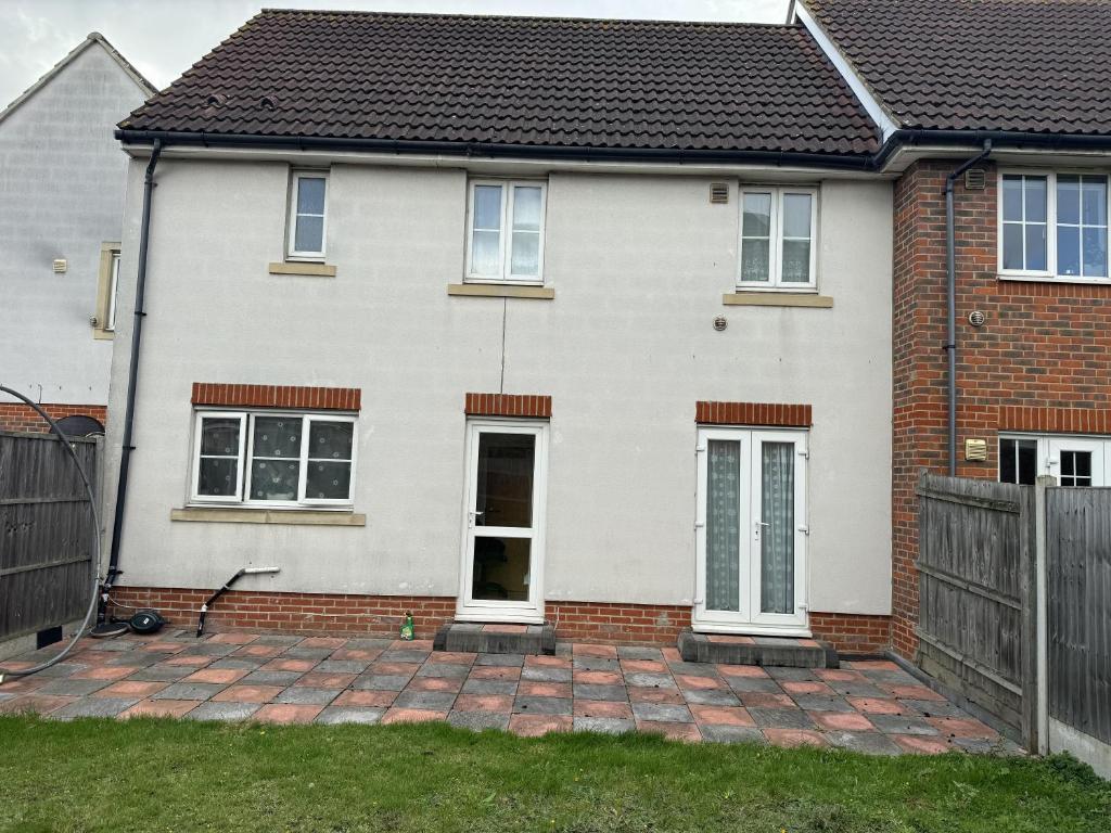 a white house with a brick driveway at Impeccable 4-Bed House in London in London