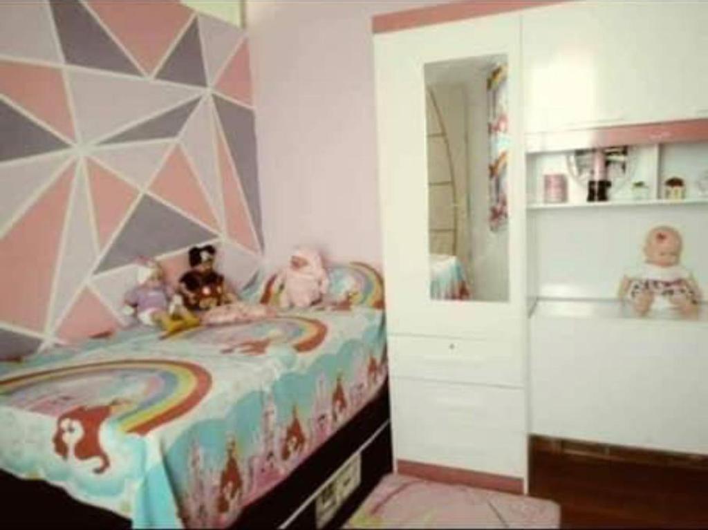 - une chambre pour enfants avec un lit arc-en-ciel dans l'établissement casa alto padrão a 30 min da praia, à Rio de Janeiro
