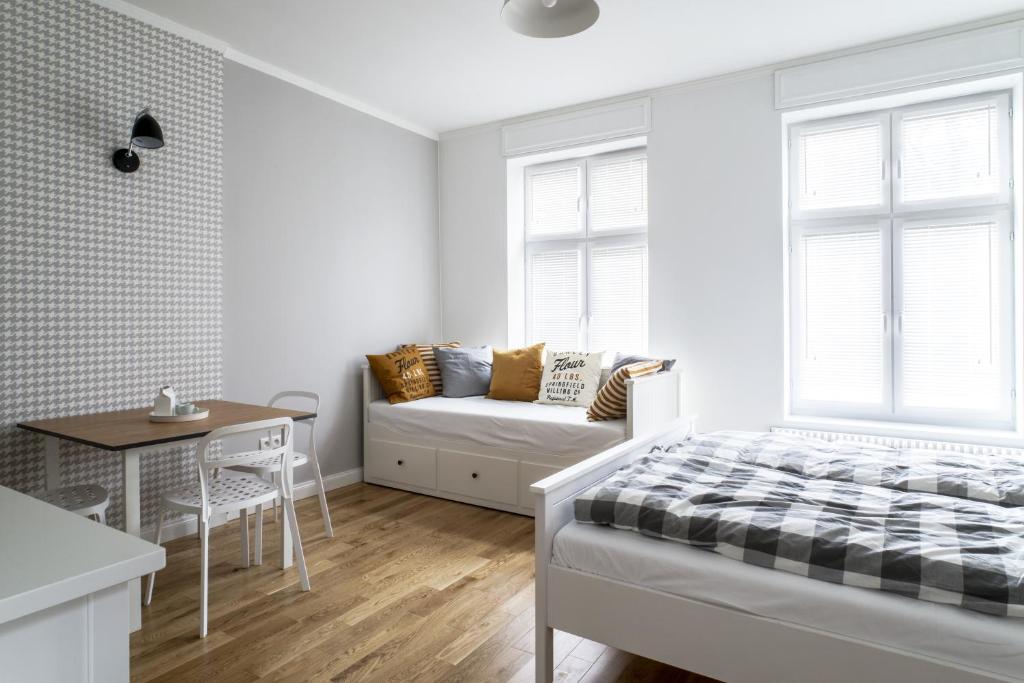 a bedroom with a bed and a table and a couch at Apartamenty Solo na Molo in Sopot