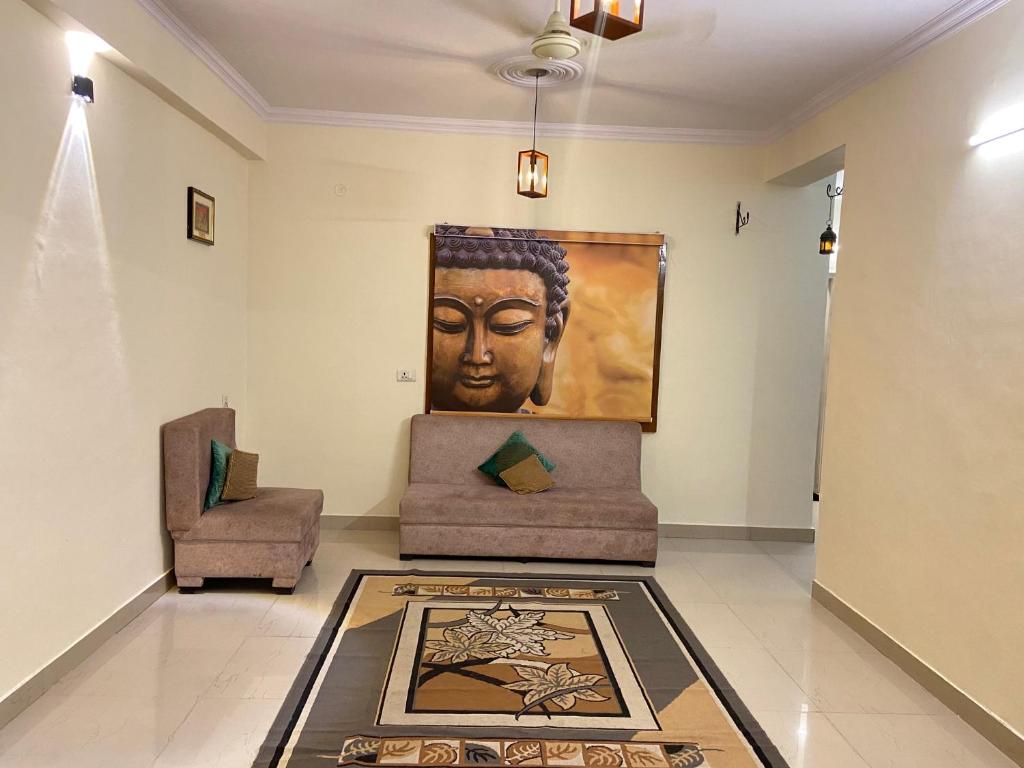 a living room with a painting of a head on the wall at Kashi Karma Homestay in Varanasi