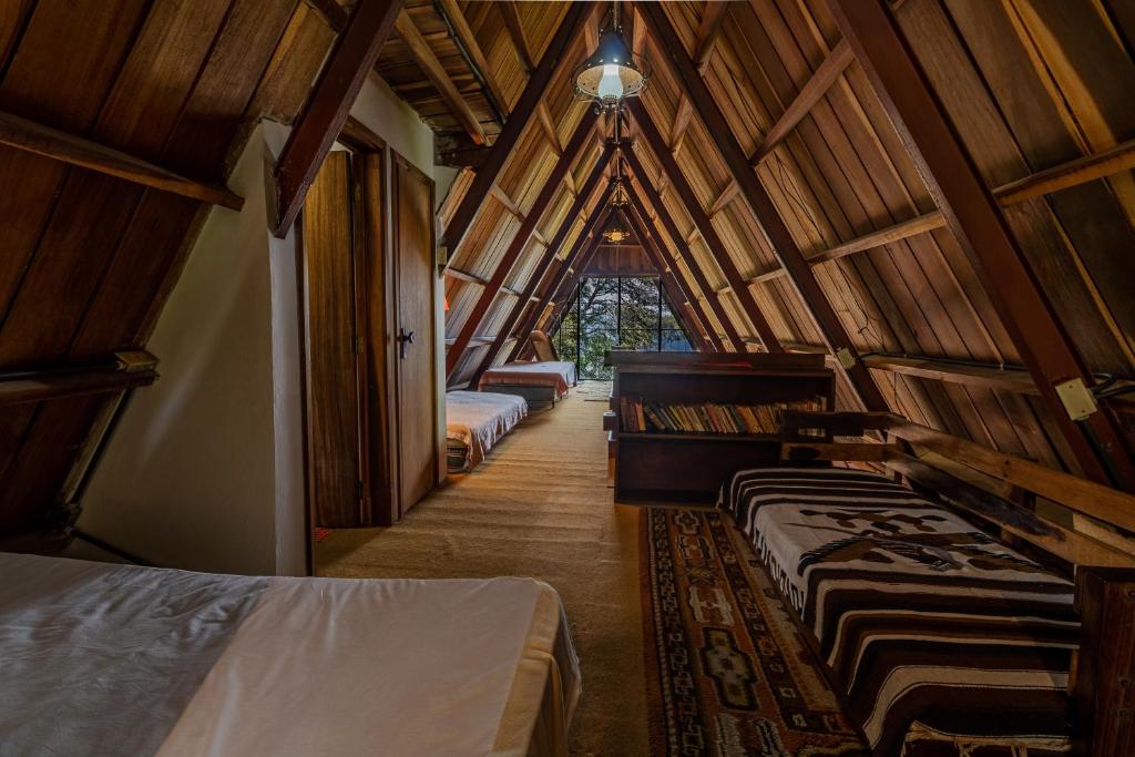 um quarto com várias camas num quarto com tectos em madeira em Chalet Lander Colonia Tovar em El Tigre