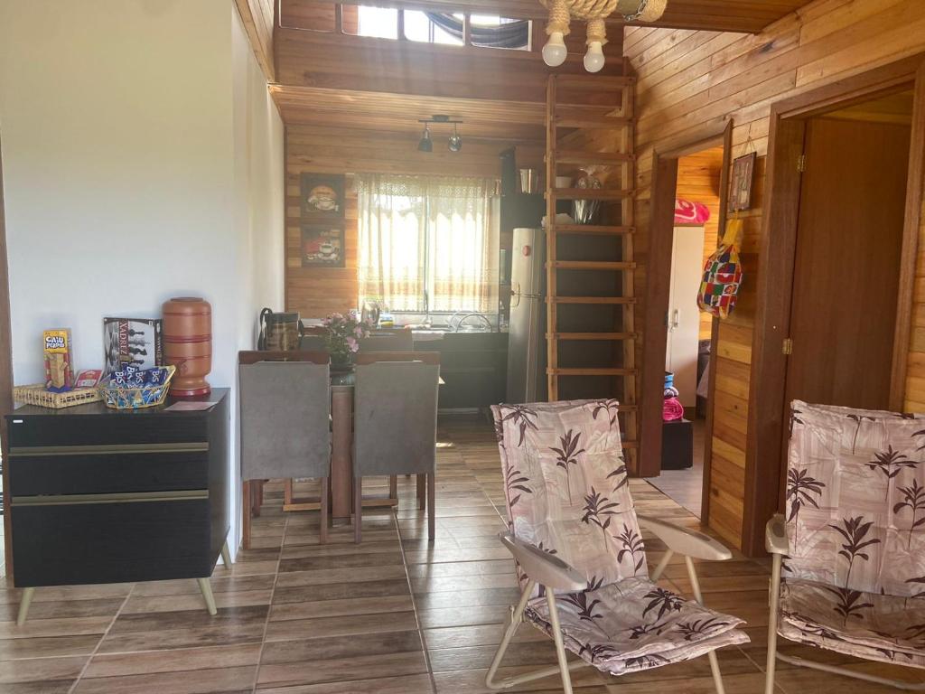 cocina y comedor con mesa y sillas en CABANA DOCE LUAR en Gravataí