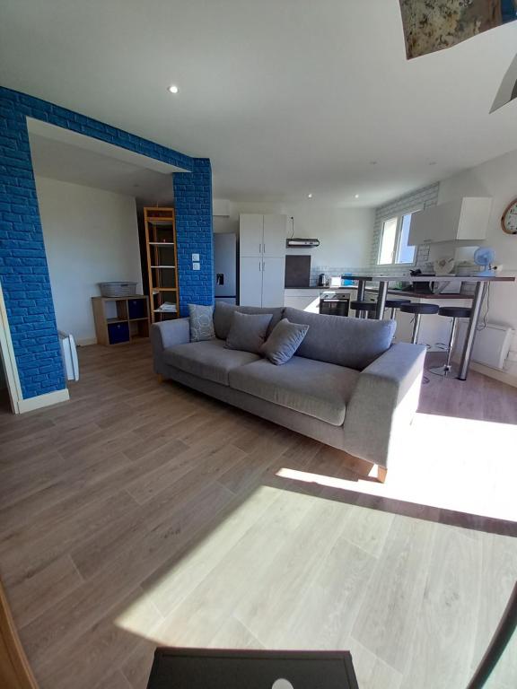 uma ampla sala de estar com um sofá e uma cozinha em L'oasis em Tarbes