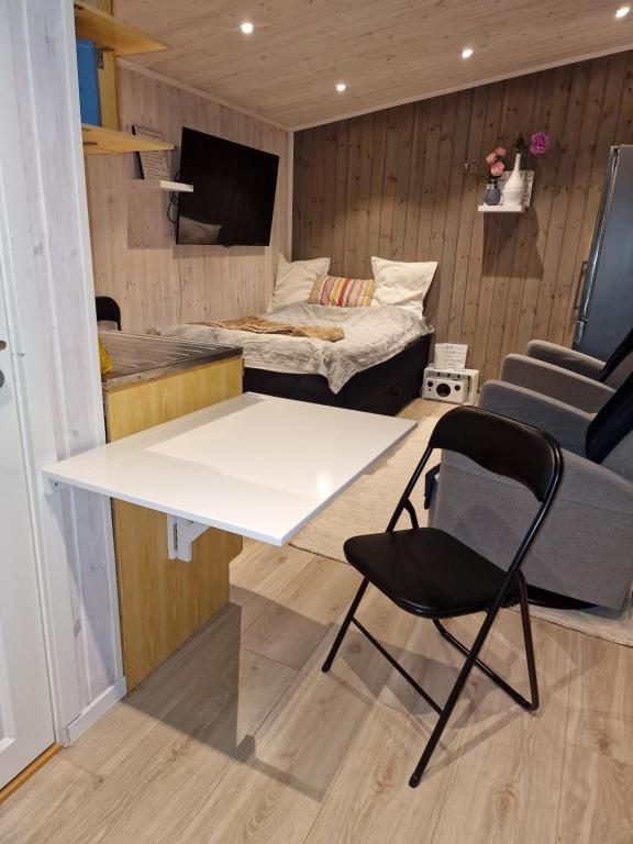 Sjarmerende anneks i Sigerfjord, Vesterålen في سورتلاند: طاولة وكرسي في غرفة مع سرير