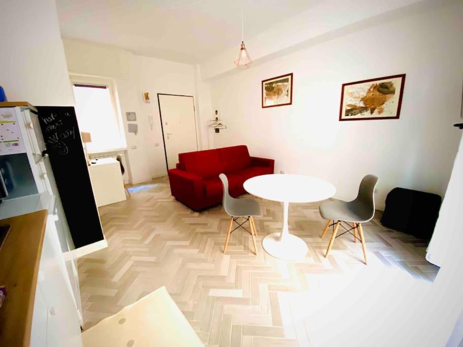 sala de estar con mesa y sofá rojo en Pupazza House, intero appartamento nel cuore di Frascati, en Frascati