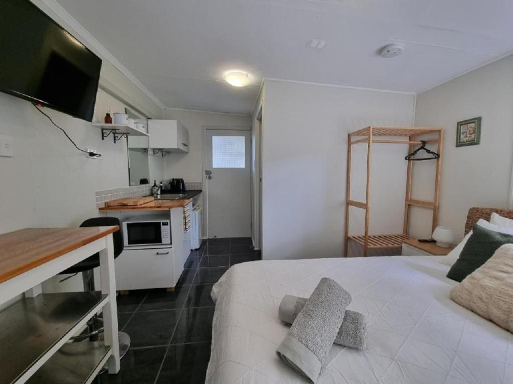 Habitación pequeña con cama y cocina en Redcliffe Homestay, en Redcliffe