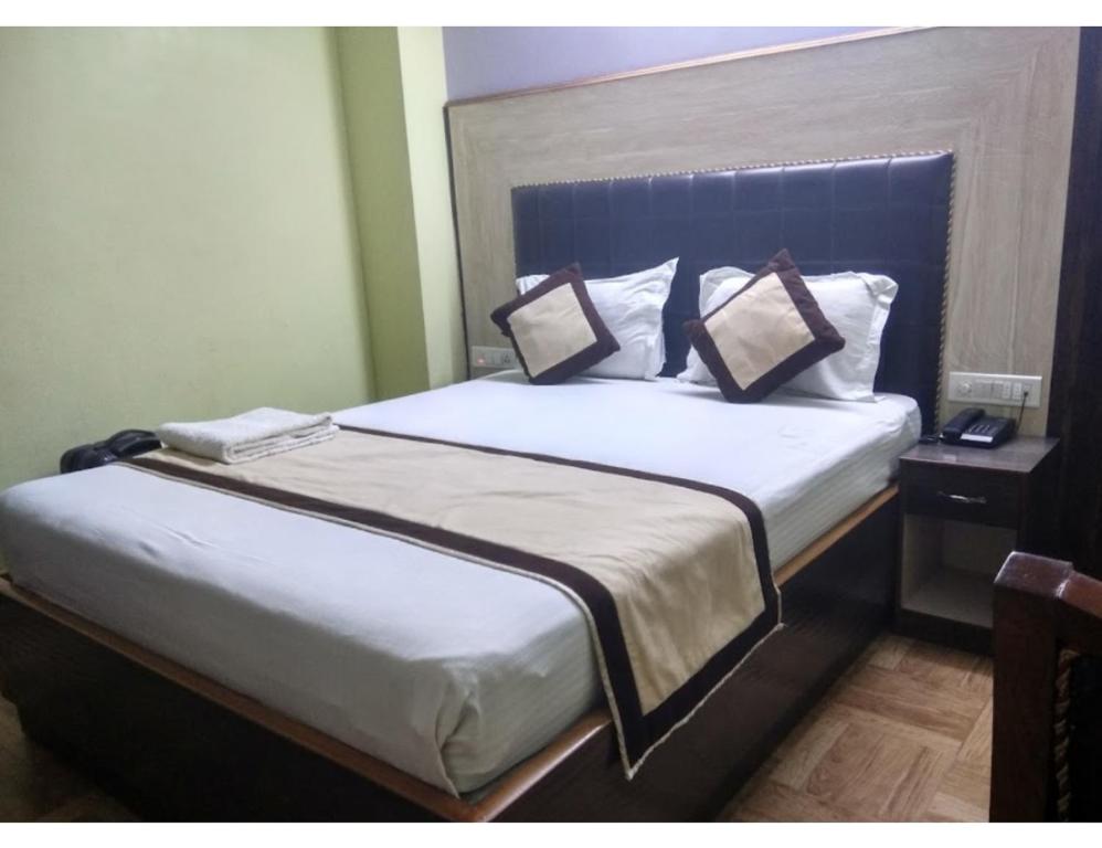 a bedroom with a bed with two pillows on it at Hotel Grand SM Regency, Darbhanga in Darbhanga