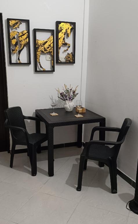 una mesa negra y dos sillas y una mesa con flores. en Aparta Estudio en Puerto Berrio, en Puerto Berrío