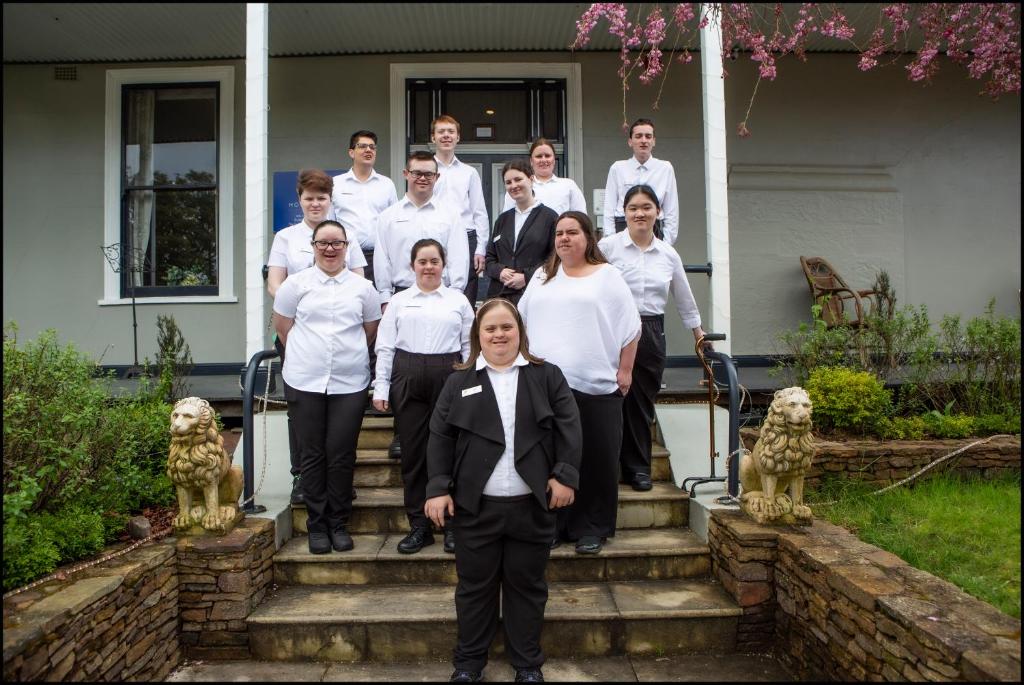 een groep mensen die op de trappen van een huis staan bij Hotel Etico at Mount Victoria Manor in Mount Victoria