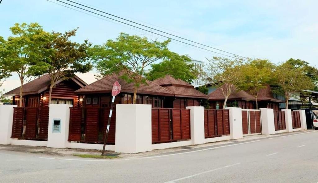 a building with a fence on the side of a street at 巴厘岛风格住宿 Muar Balinese Resort in Muar