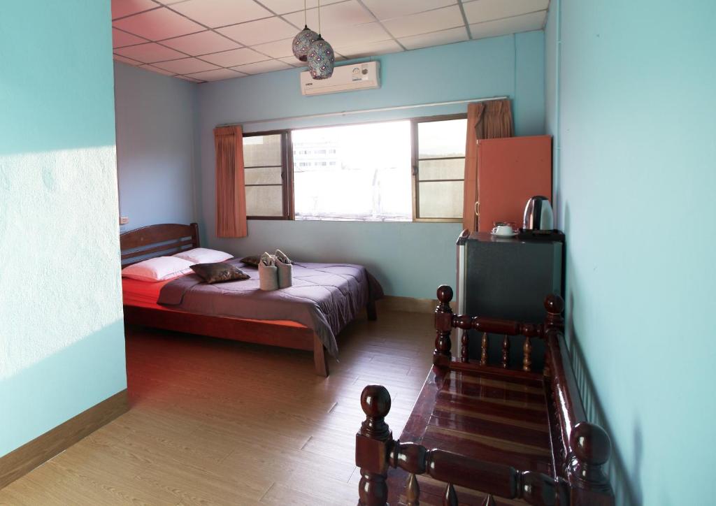 ein kleines Schlafzimmer mit einem Bett und einem Fenster in der Unterkunft Holiday Phangan - Hostel & Bar in Thongsala
