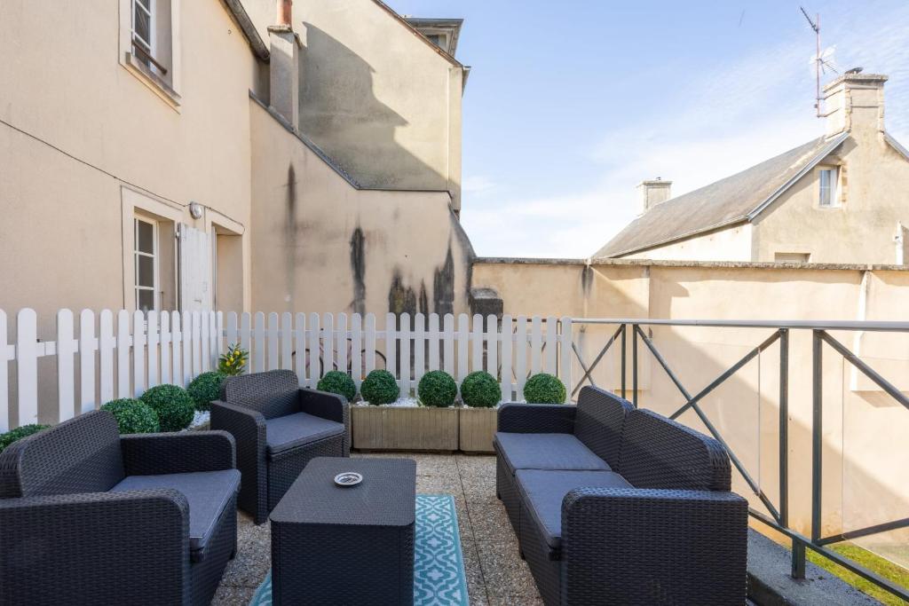 eine Terrasse mit zwei blauen Stühlen und einem Zaun in der Unterkunft Le gîte d'Isa in Bayeux