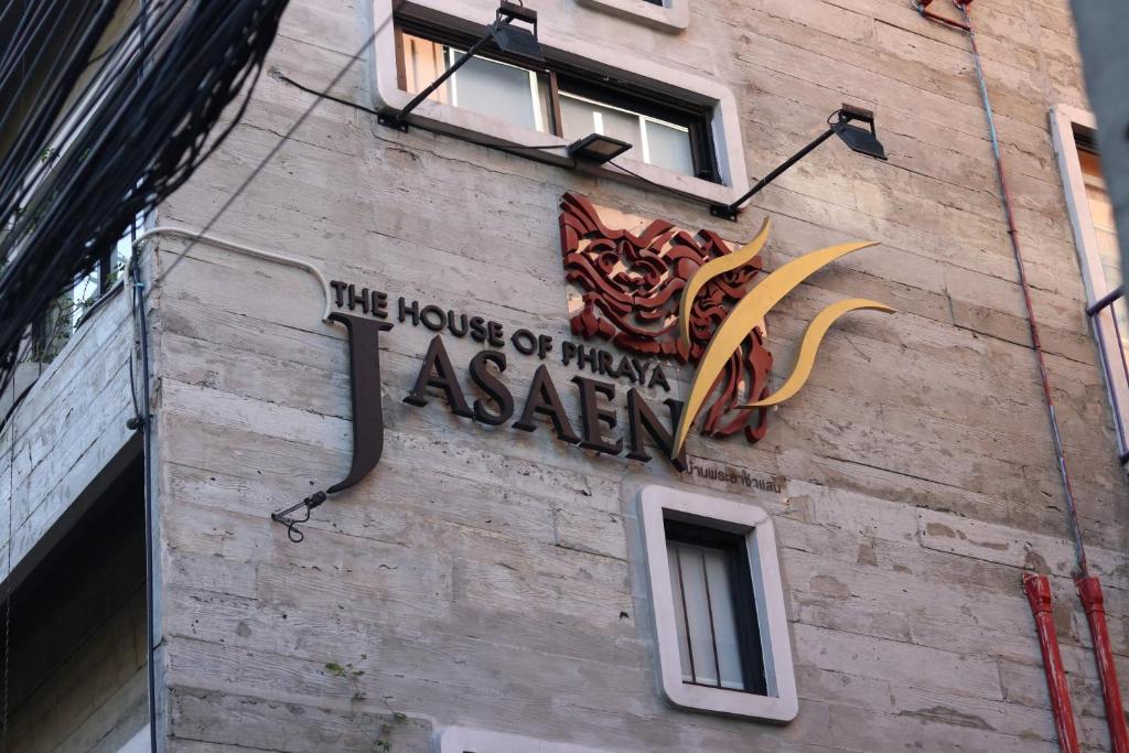 Jasaen Stylish Boutique Hotel في بانكوك: علامة على جانب مبنى عليه تنين