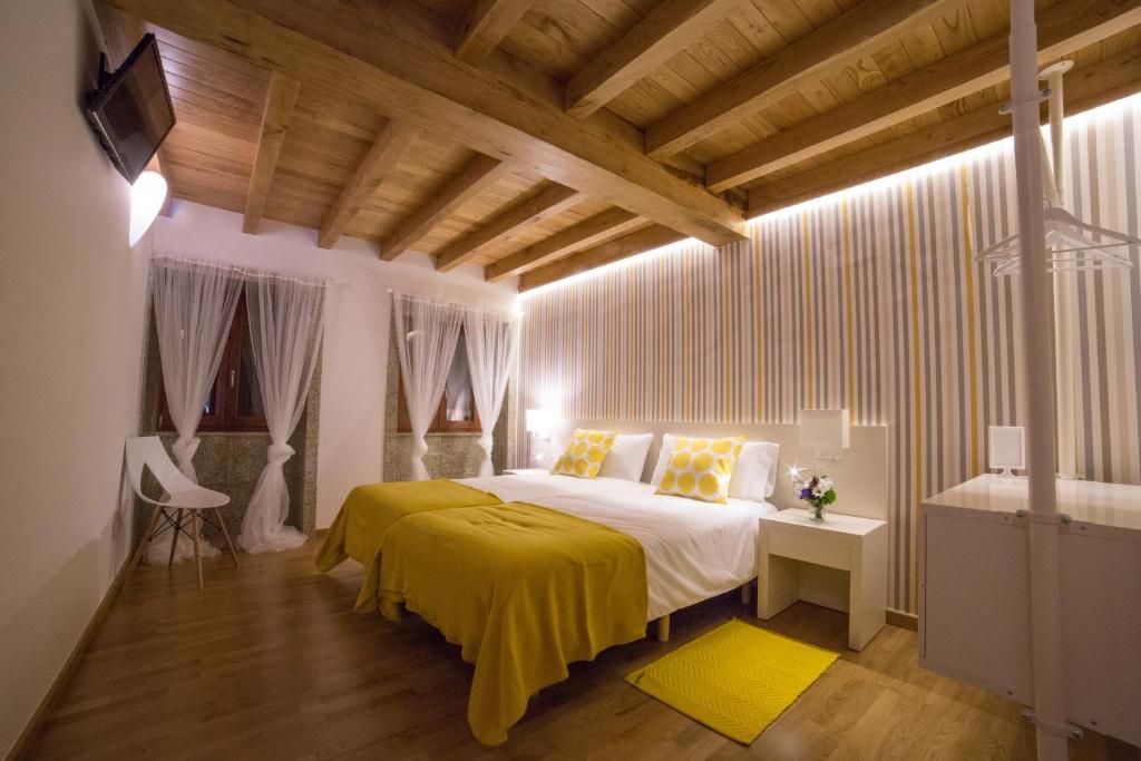 a bedroom with a bed with a yellow blanket at Casa Juancito in Santiago de Compostela