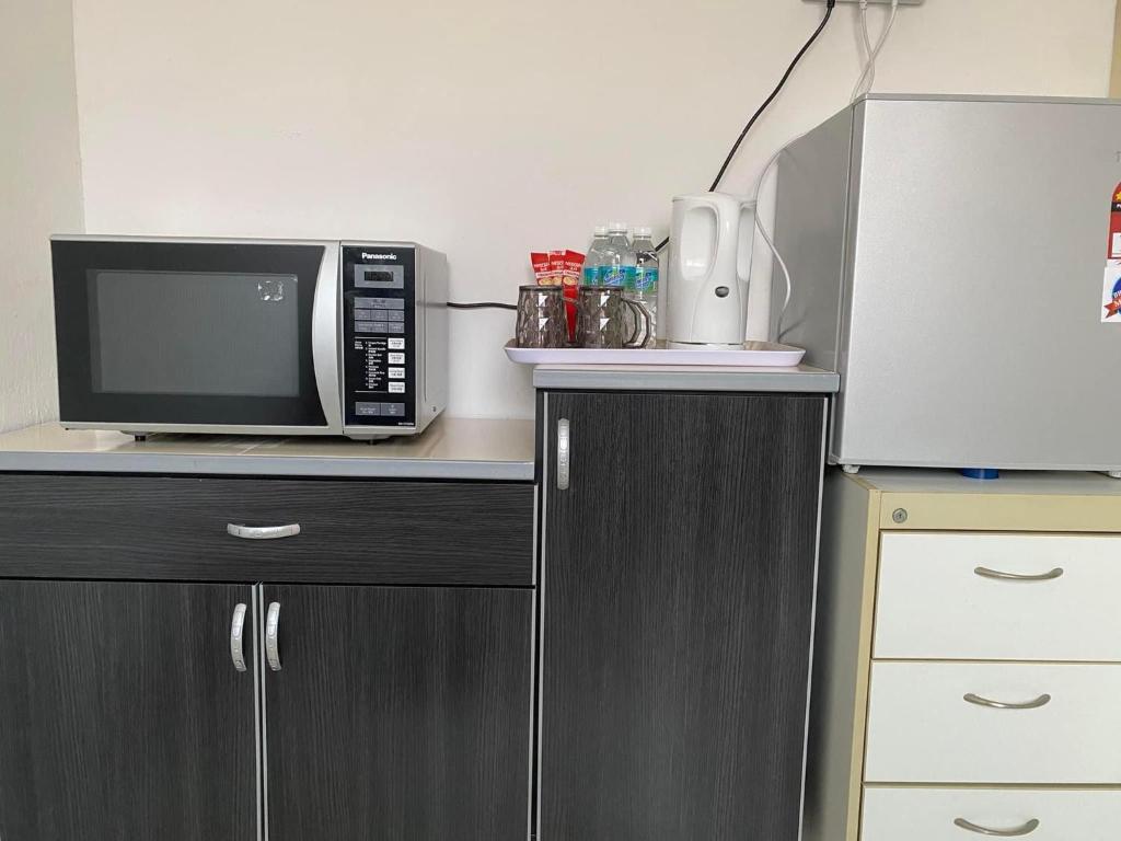 a microwave oven sitting on top of a counter at Cik Misi Homestay Jeniang in Sik