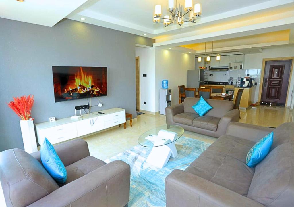 a living room with two couches and a fireplace at Urban Oasis Apartment by Edmor Suites in Nairobi