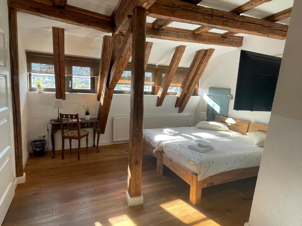 Schlafzimmer mit einem Bett, einem TV und einem Tisch in der Unterkunft Gästezimmer an der Stadtmauer in Besigheim