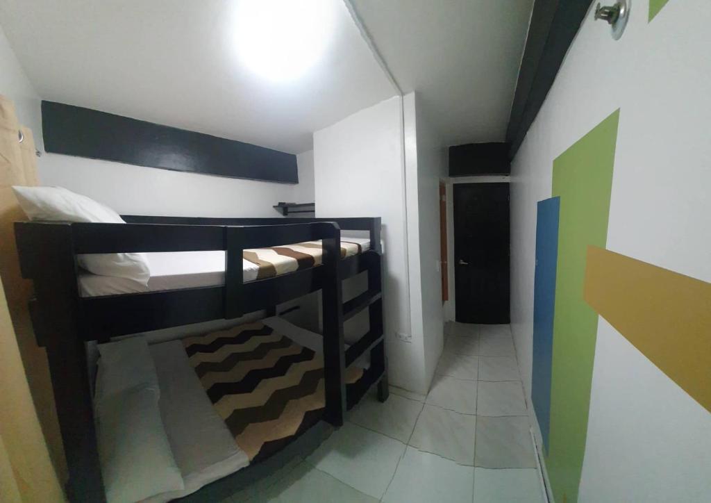 a small room with two bunk beds and a hallway at Villa Tomasa Boracay Dmall in Boracay