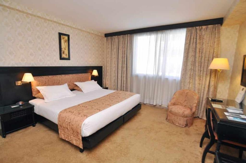 Cette chambre comprend un grand lit et une chaise. dans l'établissement Shisha lounge bar and guest house, à Juribela