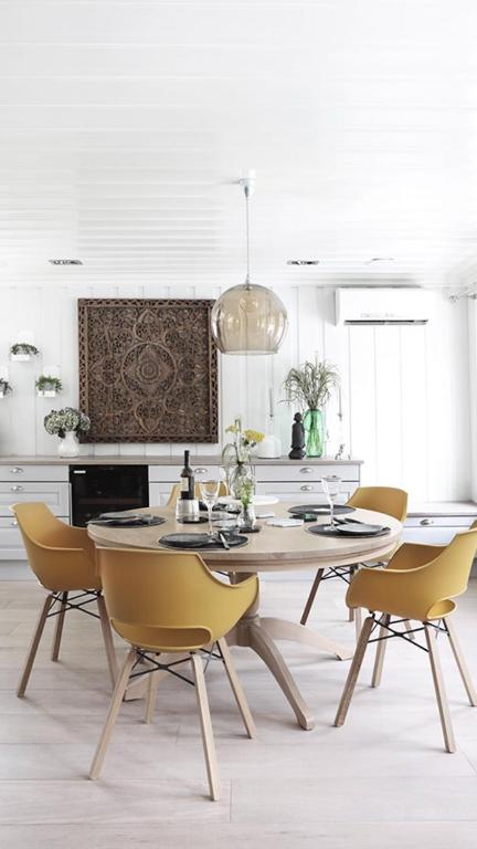 a white kitchen with a dining table and chairs at Villa Marikollen in Hektner