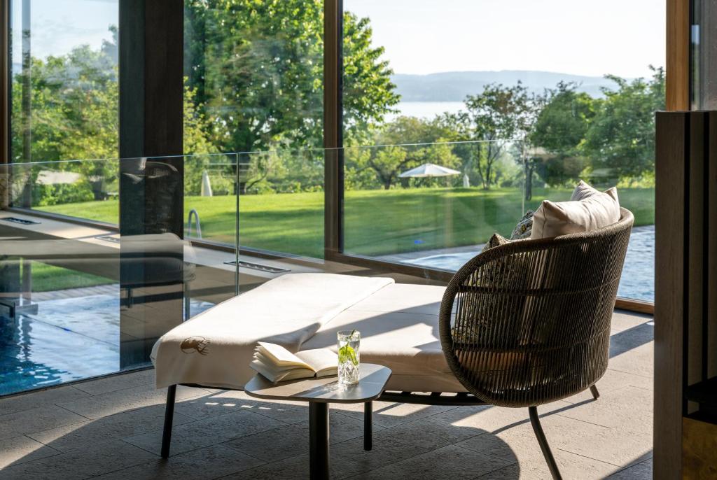 a living room with a wicker chair and a table at Hotel Hirschen Horn in Gaienhofen