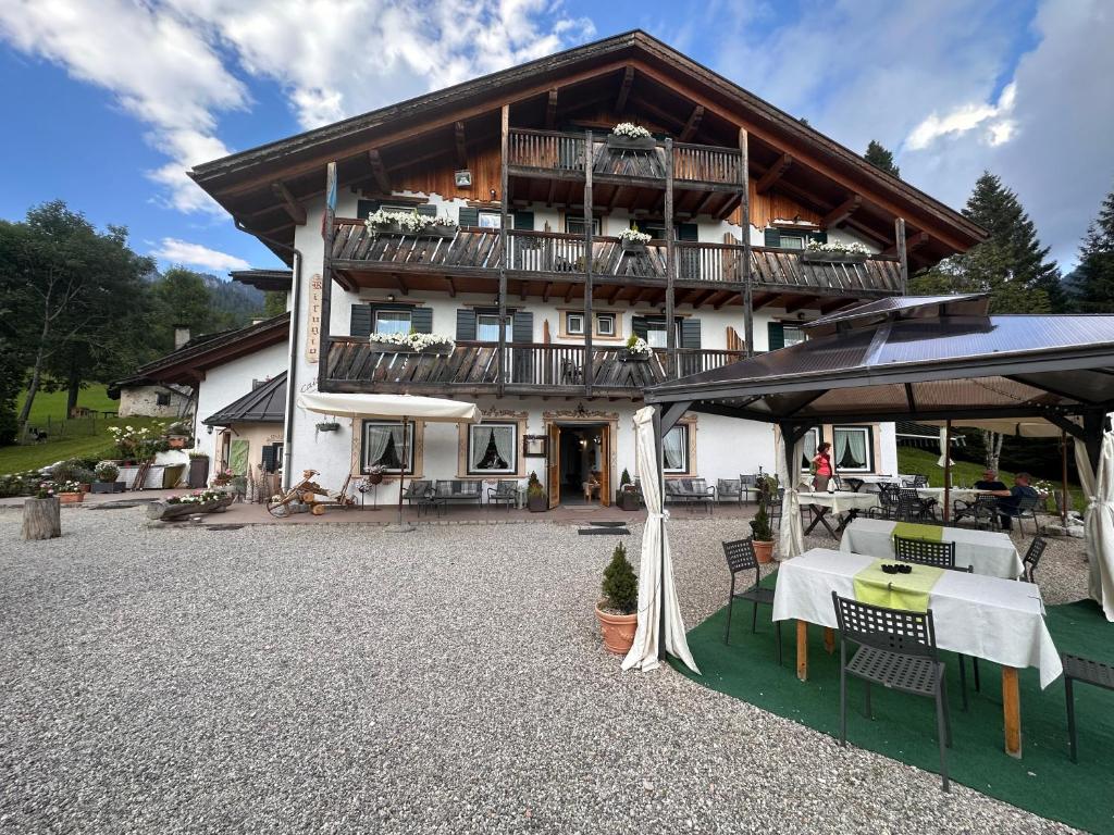a large house with a table and an umbrella at Rifugio Caltena in Fiera di Primiero