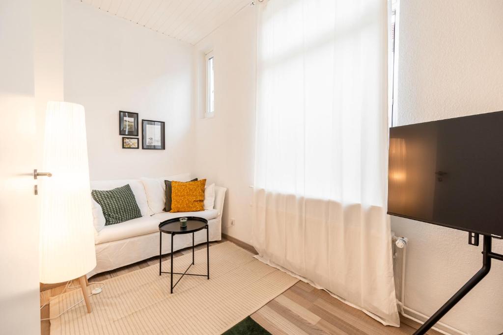 ein Wohnzimmer mit einem Sofa und einem TV in der Unterkunft Exklusive Wohnung am Weserdeich in Bremen