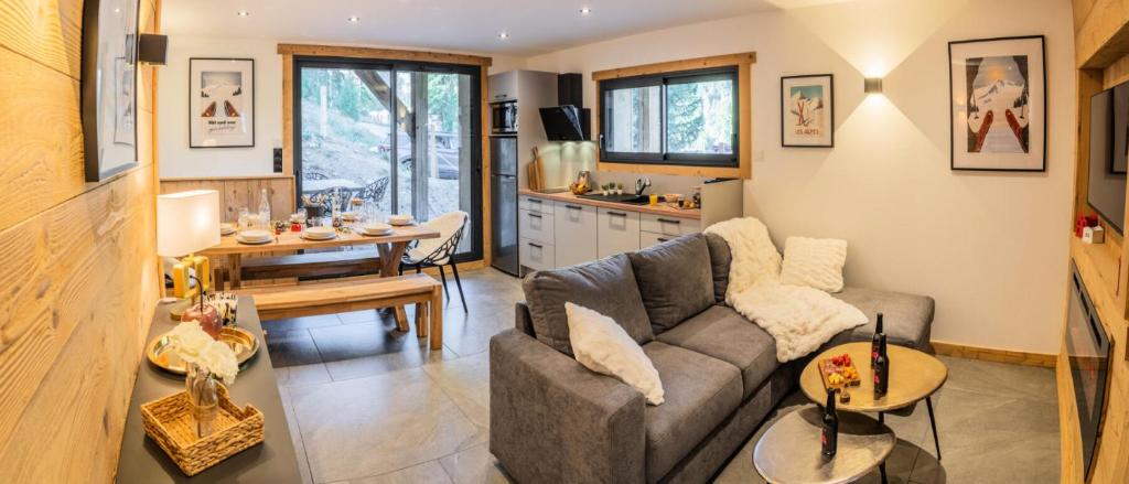 a living room with a couch and a table at Résidence Domaine Du Loup Blanc - Chalets pour 8 Personnes 514 in Les Orres