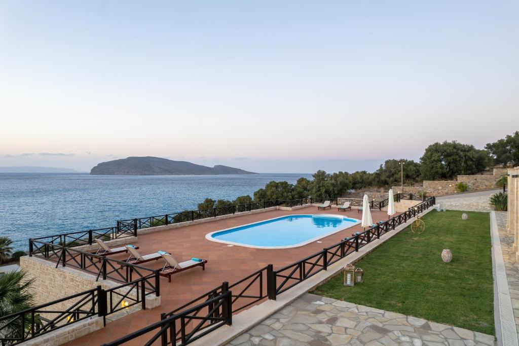 a swimming pool with the ocean in the background at Tholos Boutique Houses in Kavoúsion