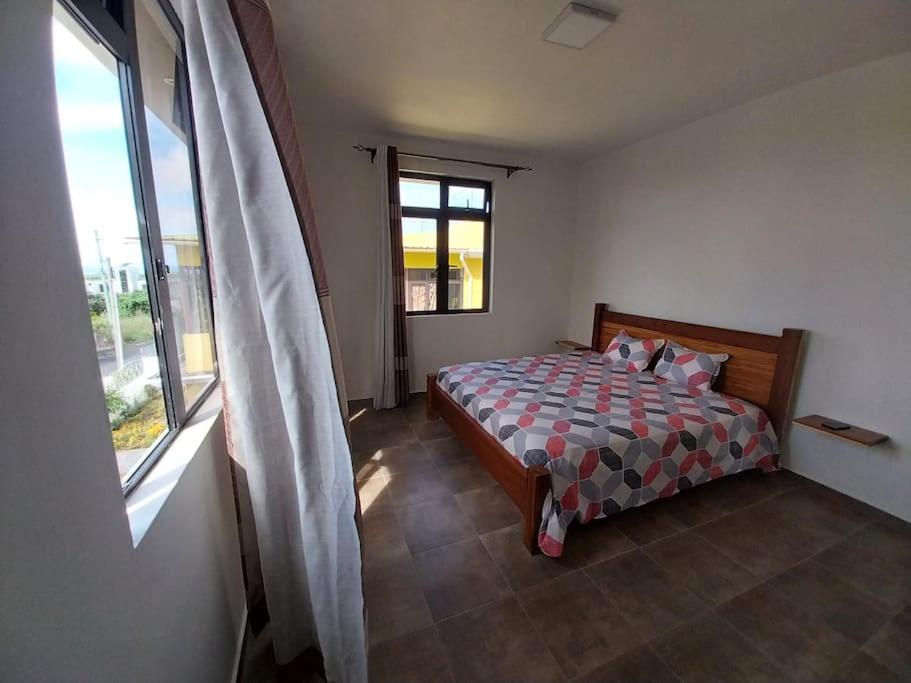 Schlafzimmer mit einem Bett und einem Fenster in der Unterkunft Villa Deux Bras 