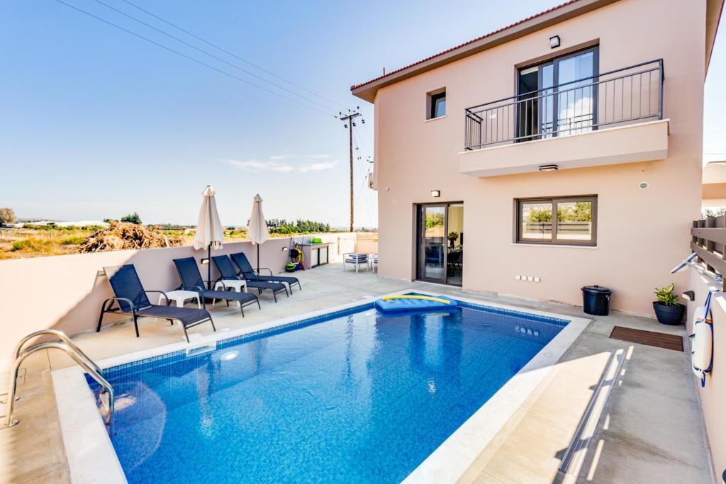 a villa with a swimming pool and a house at Villa Elpida THREE by Ezoria Villas in Timi, Paphos in Paphos