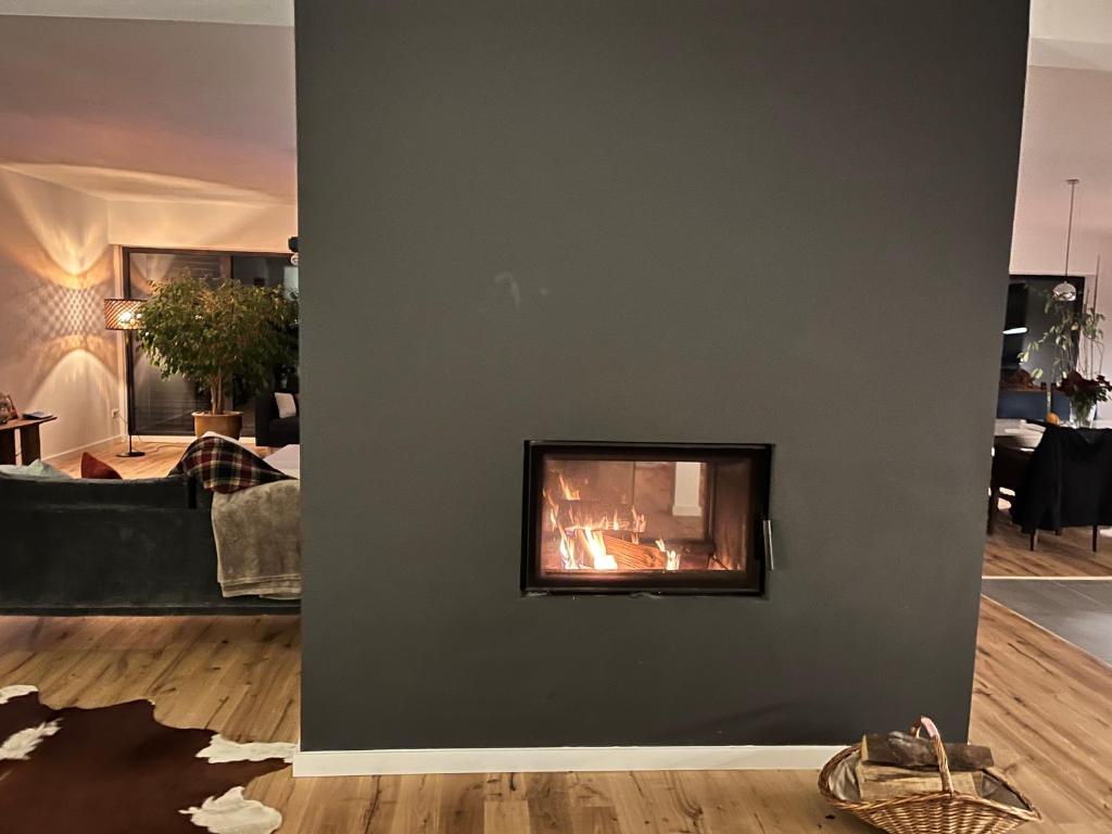 a living room with a fireplace on the wall at Maison petite Suisse luxembourg in Berdorf