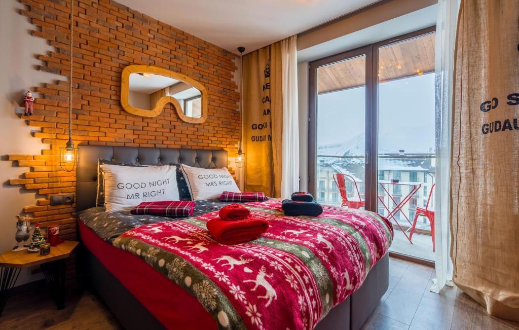 um quarto com uma cama com uma parede de tijolos em New Gudauri Ski4Life em Gudauri