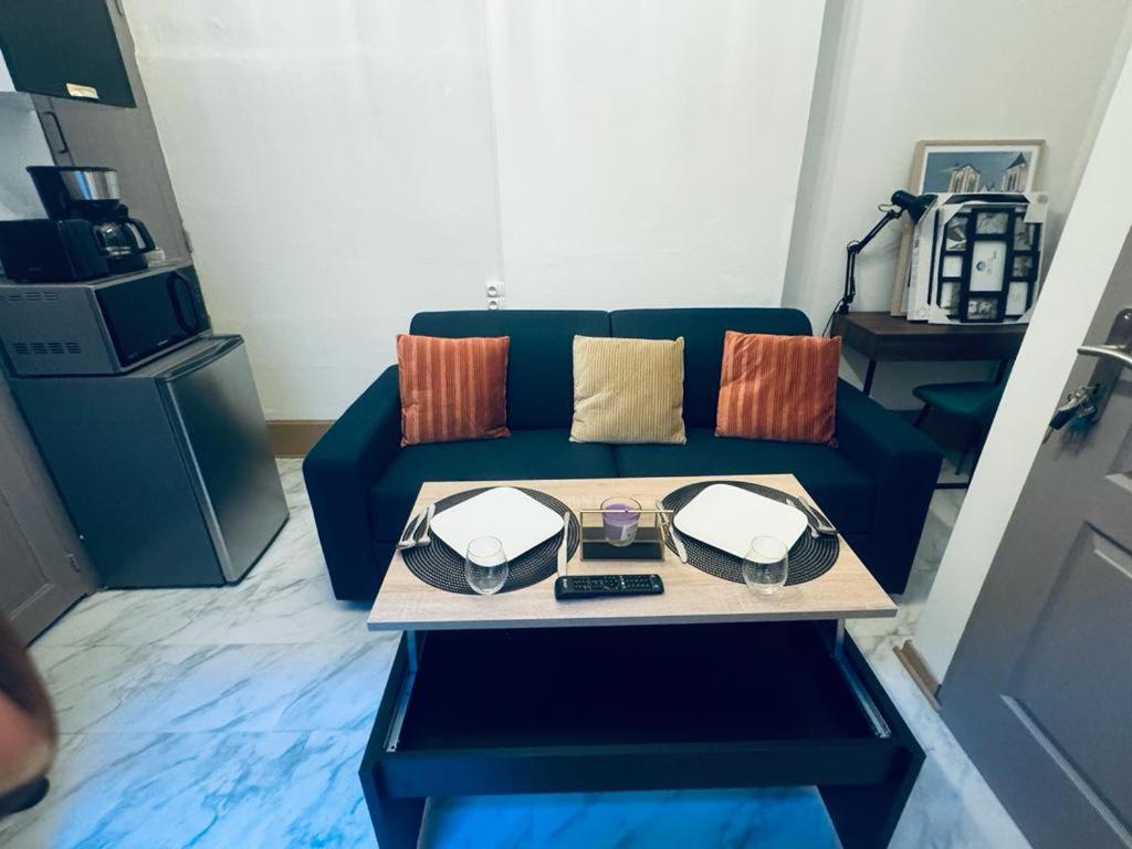 un salon avec un canapé bleu et une table dans l'établissement Le green touch, studio centre ville historique, à Bourges